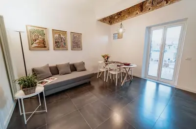 a living room with a couch and a table and chairs at casaDamare in Palermo