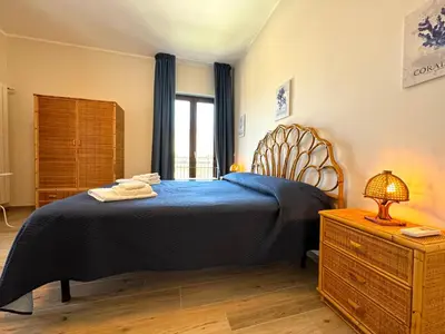 a bedroom with a blue bed and a dresser and a window at Casa di Mami in Capaci