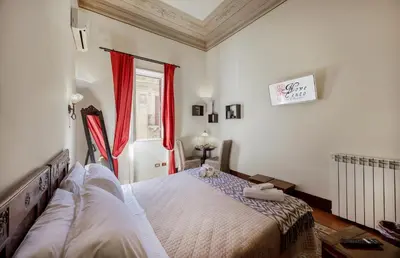 a bedroom with a bed and a window with red curtains at B&B Novecento in Palermo