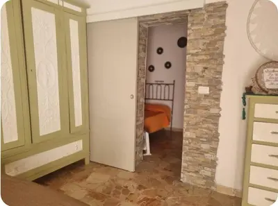a room with a green door and a bedroom at Casa Mimì in Castellammare del Golfo