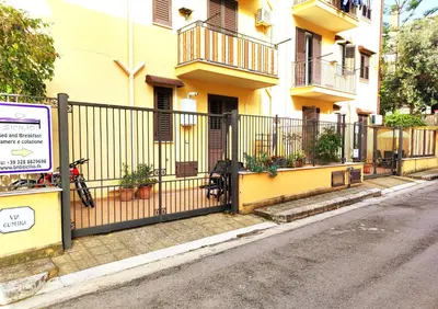 a fence in front of a building next to a street at B&B Siciliò in Santa Flavia