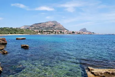 a large body of water with a mountain in the background at B&B Siciliò in Santa Flavia