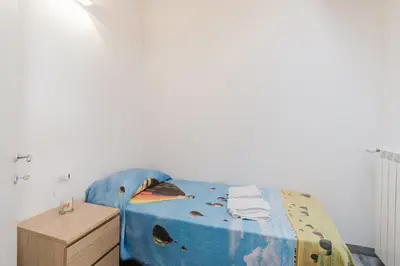a bedroom with a bed with a blue comforter and a wooden cabinet at Costa del Golfo in Castellammare del Golfo