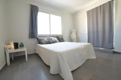 a white bedroom with a large bed with a window at STANZINA DELLA BARONESSA in Carini