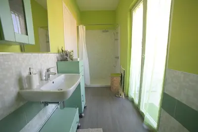 a green bathroom with a sink and a mirror at STANZINA DELLA BARONESSA in Carini