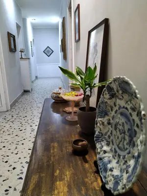 a living room with a table and a plant at Genio del Porto - Mabbonath in Palermo
