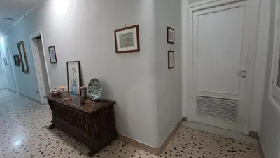 a hallway with a wooden table and a white wall at Genio del Porto - Mabbonath in Palermo