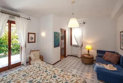 a living room with a blue couch and a window at casa Morgana in Palermo