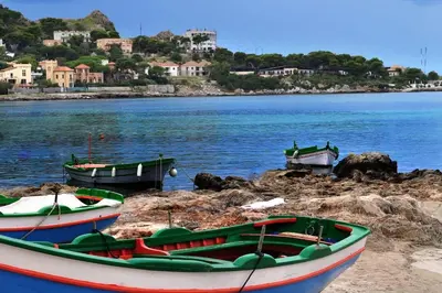 two boats sitting on the shore of a body of water at casa Morgana in Palermo