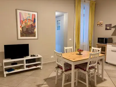 a kitchen and dining room with a table and a television at Palermo Centre - Apartments with Private Balcony or Terrace in Palermo
