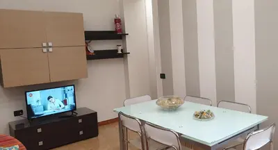 a living room with a table with chairs and a tv at Casa Vacanze L'isola del Relax in Isola delle Femmine
