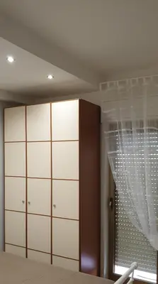 a bedroom with white cabinets and a window at Casa Vacanze L'isola del Relax in Isola delle Femmine