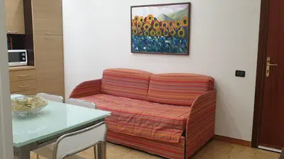 a couch in a room with a table and a painting at Casa Vacanze L'isola del Relax in Isola delle Femmine