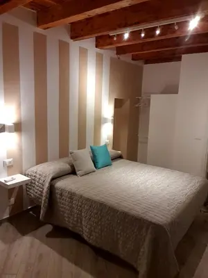 a bedroom with a bed with a striped wall at Casa Margò in Monreale