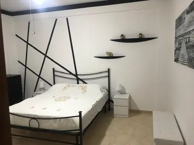 a bedroom with a bed and shelves on the wall at Appartamento 60 mq a 800 mt dalla spiaggia in Capaci