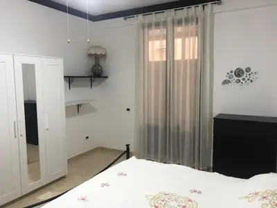 a bedroom with a bed and a large window at Appartamento 60 mq a 800 mt dalla spiaggia in Capaci