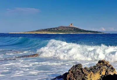 an island in the ocean with waves and a rock at Appartamento 60 mq a 800 mt dalla spiaggia in Capaci