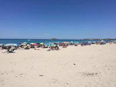 a group of people on a beach with umbrellas at Appartamento 60 mq a 800 mt dalla spiaggia in Capaci