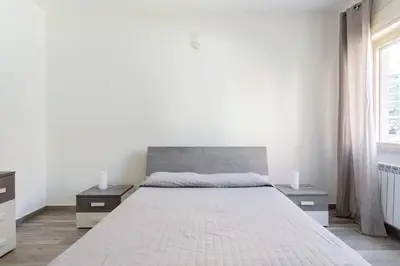 a white bedroom with a large bed with two night stands at E.R. Apartment in Palermo