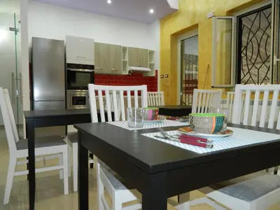 a kitchen with a black table and white chairs at LE STANZE DI LUCA in Palermo