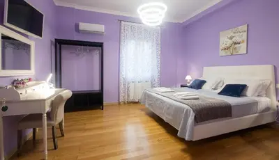 a purple bedroom with a bed and a desk at LE STANZE DI LUCA in Palermo