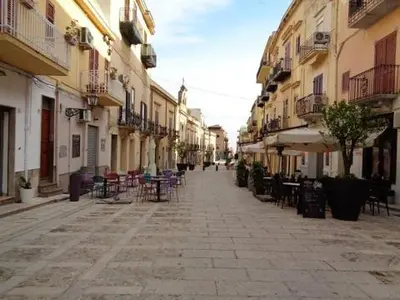 an empty street with chairs and tables and buildings at Casa Lidia in Castellammare del Golfo