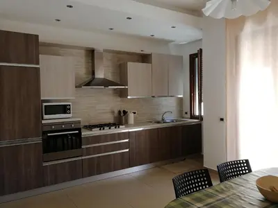 a kitchen with wooden cabinets and a stove top oven at Casa Lidia in Castellammare del Golfo
