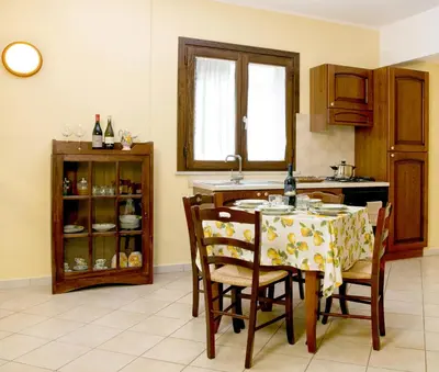 a kitchen with a table and chairs and a counter at Sosta dei Garibaldini in Campofelice di Roccella