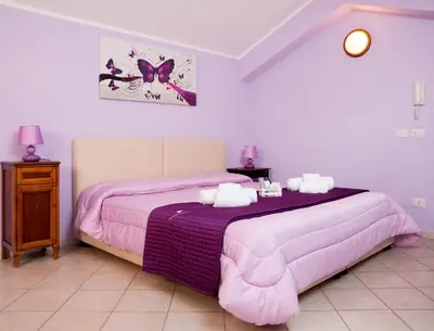 a bedroom with two beds with pink comforter at Sosta dei Garibaldini in Campofelice di Roccella