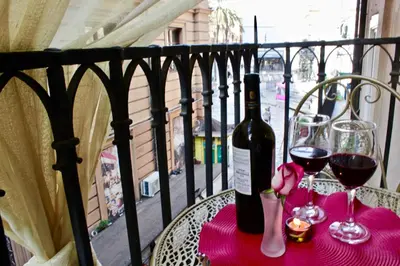 a table with a bottle of wine and two glasses at VUCCIRIA 57 locazione turistica nel cuore pulsante della movida! in Palermo