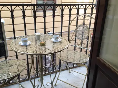 a small table with two chairs and cups on a balcony at VUCCIRIA 57 locazione turistica nel cuore pulsante della movida! in Palermo