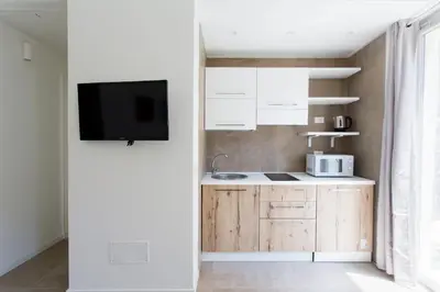 a kitchen with white cabinets and a tv on a wall at Stabile Central Studios in Palermo