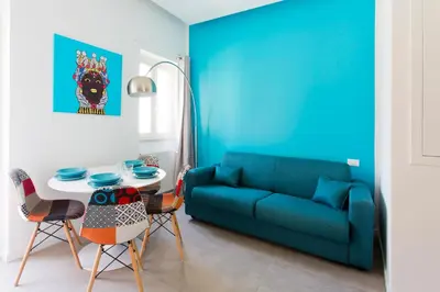 a living room with a blue couch and a table at Stabile Central Studios in Palermo