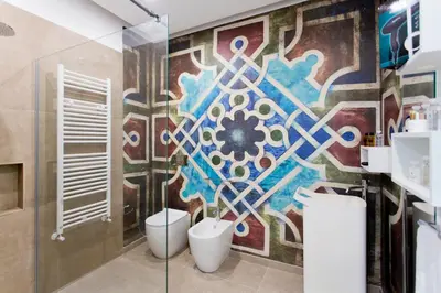 a bathroom with a colorful mural on the wall at Stabile Central Studios in Palermo
