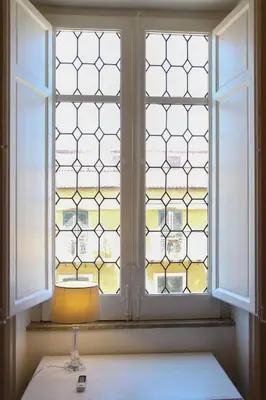 a lamp sitting on a table in front of a window at Le case d'un tempo in Palermo