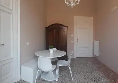 a dining room with a white table and chairs at Le case d'un tempo in Palermo