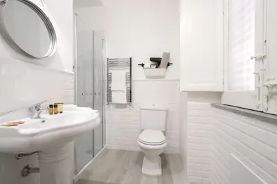 a white bathroom with a sink and a toilet at Le case d'un tempo in Palermo