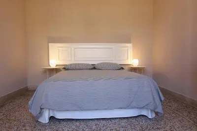 a bedroom with a bed with two lamps on two tables at Le case d'un tempo in Palermo