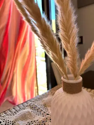 two feathers in a vase sitting on a table at Bed And Breakfast Turi in Castelluzzo
