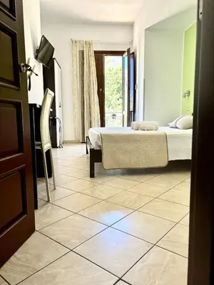 a bedroom with a bed and a tiled floor at Bed And Breakfast Turi in Castelluzzo