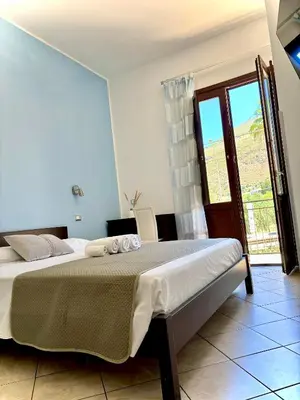 a bedroom with a bed and a large window at Bed And Breakfast Turi in Castelluzzo