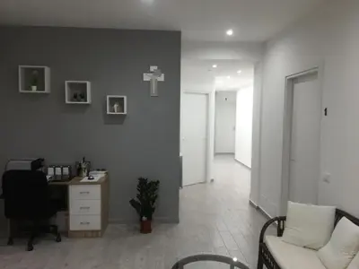 a living room with a desk and a cross on the wall at La Ruota B&B in Terrasini