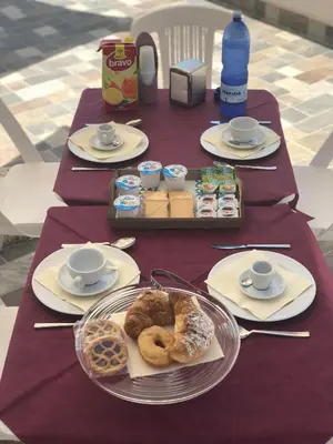 a table with plates of pastries and cups on it at La Ruota B&B in Terrasini