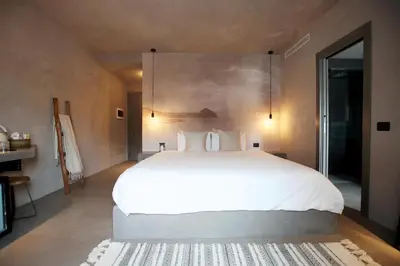 a bedroom with a large white bed and a table at Casa Nostra Boutique Hotel & Spa in Palermo