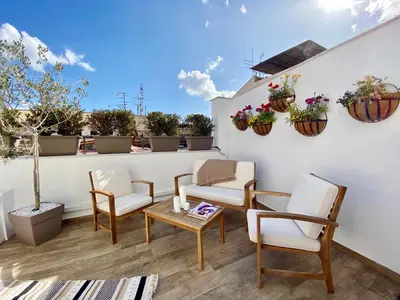 a balcony with chairs and tables and potted plants at Casa Nostra Boutique Hotel & Spa in Palermo