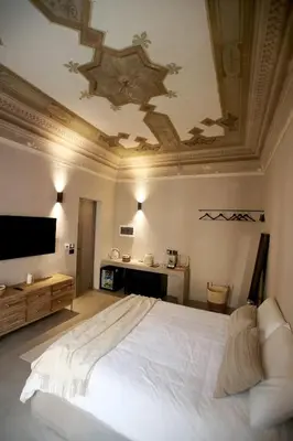 a bedroom with a large white bed with a ceiling at Casa Nostra Luxury Suites & Spa in Palermo