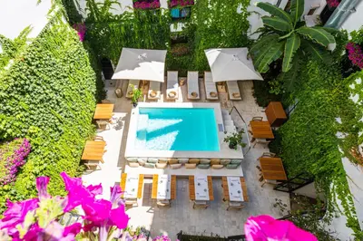 an overhead view of a swimming pool with chairs and umbrellas at Casa Nostra Luxury Suites & Spa in Palermo