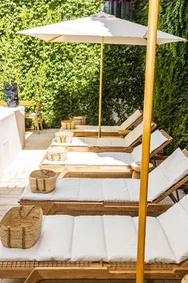 a group of lounge chairs with an umbrella on a patio at Casa Nostra Luxury Suites & Spa in Palermo