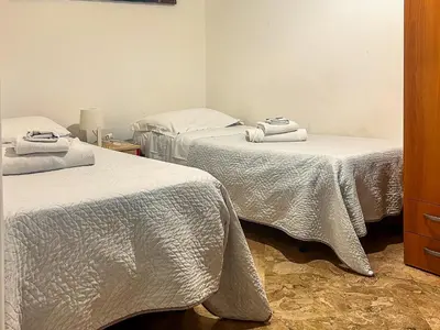 two beds in a room with white sheets and towels at Cheap in Center in Palermo