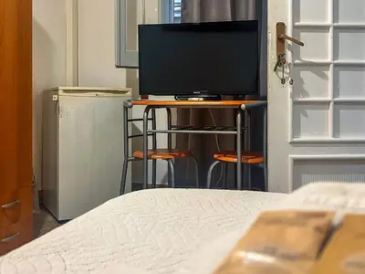 a bedroom with a bed and a television on a table at Cheap in Center in Palermo
